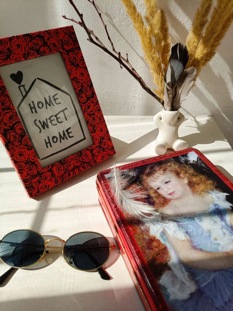 Decorative tin boxes repurposed as creative home storage solutions, organized on a shelf.