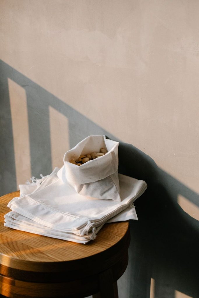 Reusable cotton bags with small brand logos, showcasing eco-friendly packaging that promotes sustainability.