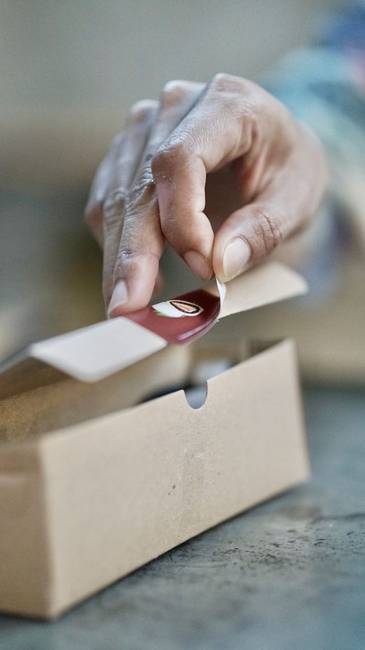 Person reading a step-by-step guide on proper package wrapping techniques with packing materials nearby.